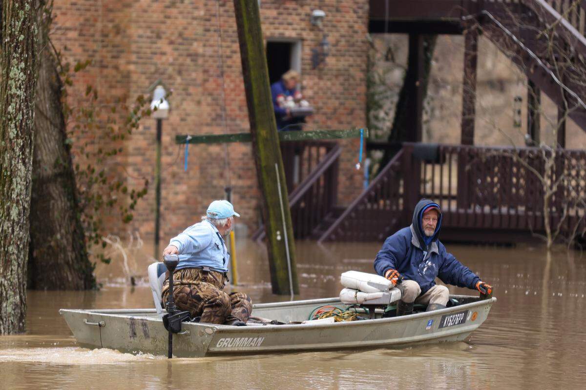 Ralph Senninger (left) uses a boat to help residents on Beach Road in Lexington, Ky., on Monday, March 1, 2021. Some residents were evacuated from the area after heavy rain caused flooding along the Kentucky River.