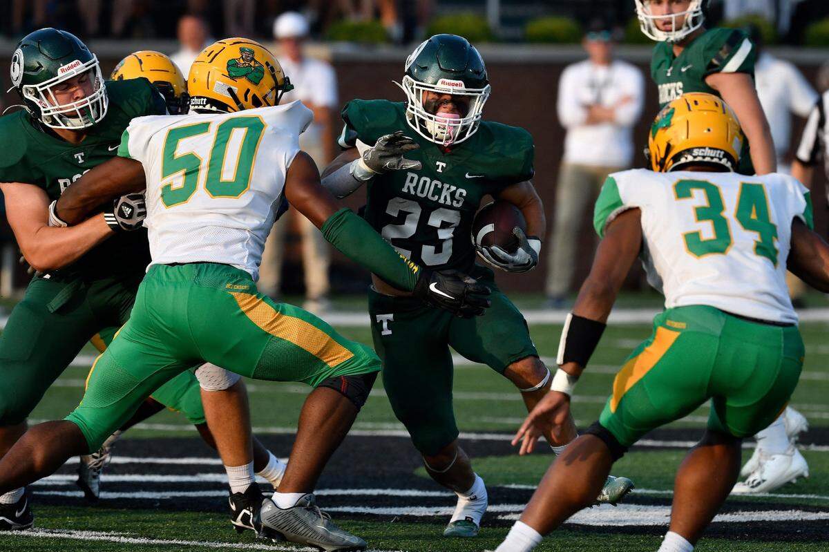 Trinity's running back Clint Sansbury runs through an opening in the Bryan Station line during the first half of their game against Bryan Station, Friday, Aug. 18 2023 in Louisville Ky.