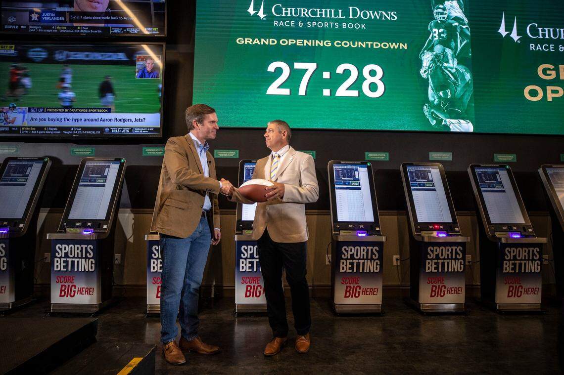 Kentucky Gov. Andy Beshear shakes hands with Mike Anderson, Churchill Downs Racetrack president, before placing the first sports wager at Churchill Downs in Louisville, Ky., on Thursday, Sept. 7, 2023. A new bill in the General Assembly would raise the age limit for legally wagering on sports in Kentucky from 18 to 21.