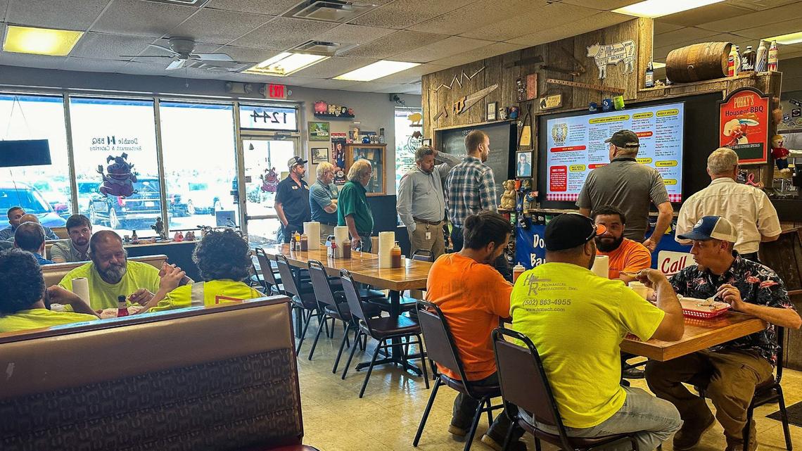 A crowded dining room fills Double H BBQ as customers order at the counter.