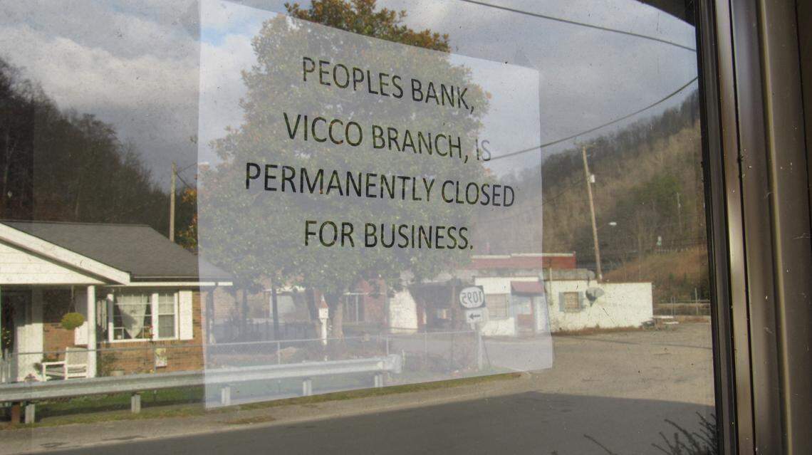 A sign taped to the door announces that a bank in downtown Vicco has been closed for good. The town itself could also be dissolved under a 2022 law.