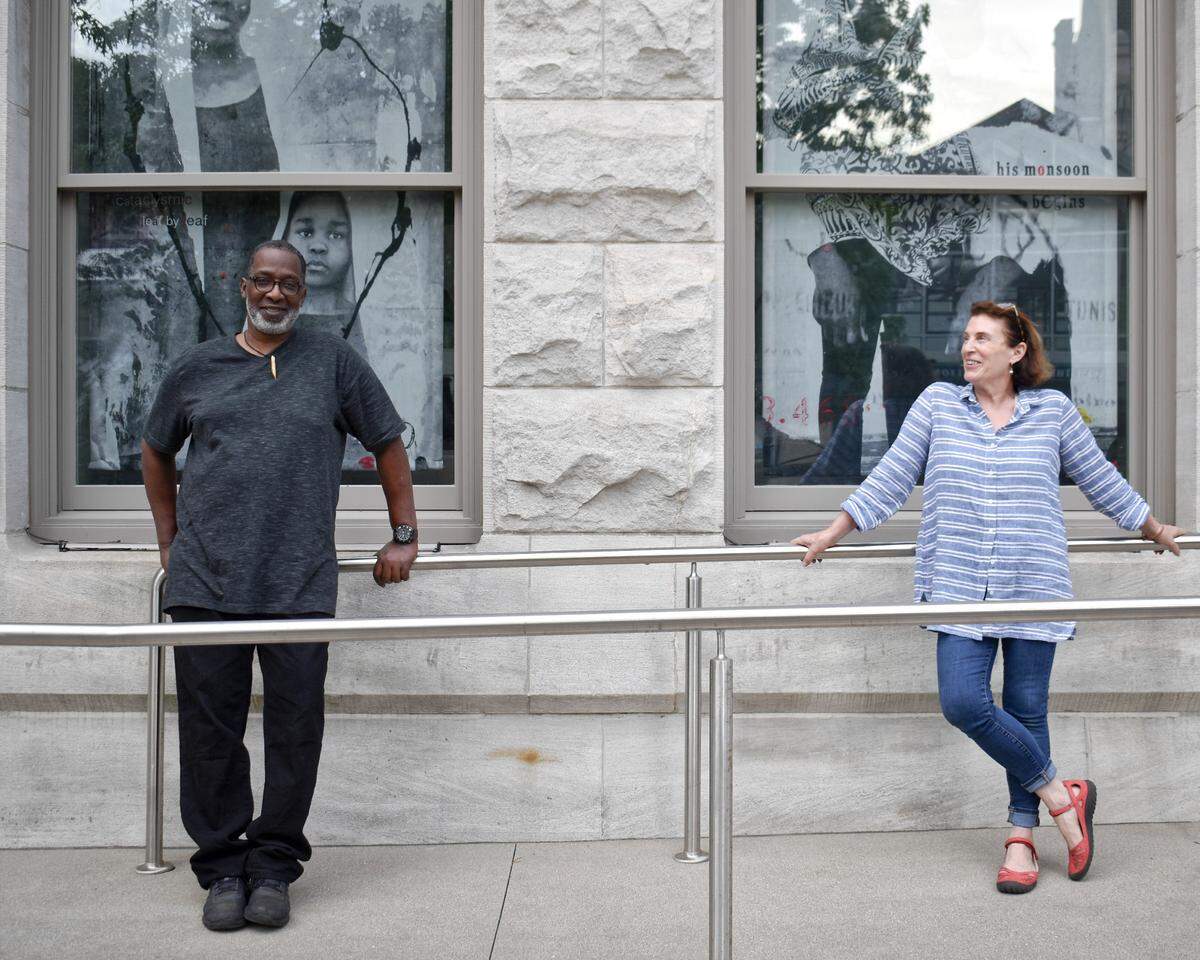 Lexington photographer Patrick Mitchell and artist Marjorie Guyon with two of the photo-collage tapestries they created, along with poet Nikky Finney, to raise awareness of the human toll of slavery. The works are on display in downtown landmarks and will expanding to more libraries.