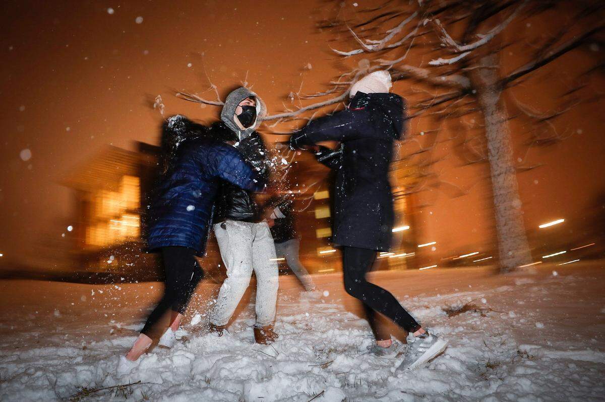 University of Kentucky students Catherine Shu, of Atlanta, Ga., from left, Justin Turner, also of Atlanta, and Kendall Coffey, of Boston, Mass., have a snowball fight near UKÕs William T Young Library in Lexington, Ky., Wednesday, Jan. 27. 2021.