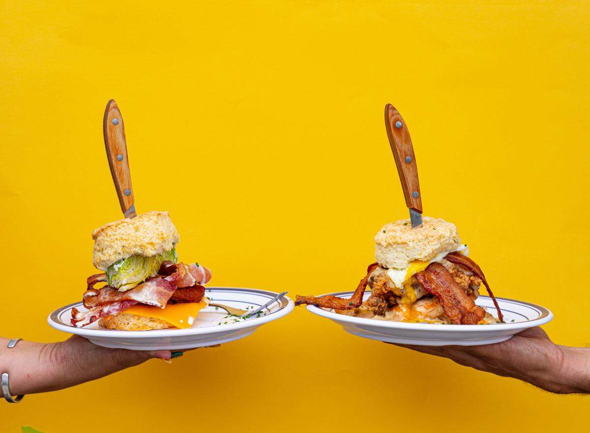 Towanda’s BLT, left, features bacon, lettuce wedge, fried green tomatoes, blue cheese dressing while the Rockwell Supreme from Biscuit Belly features buttermilk fried chicken thigh, cheddar, goetta sausage gravy, an over easy egg and bacon.