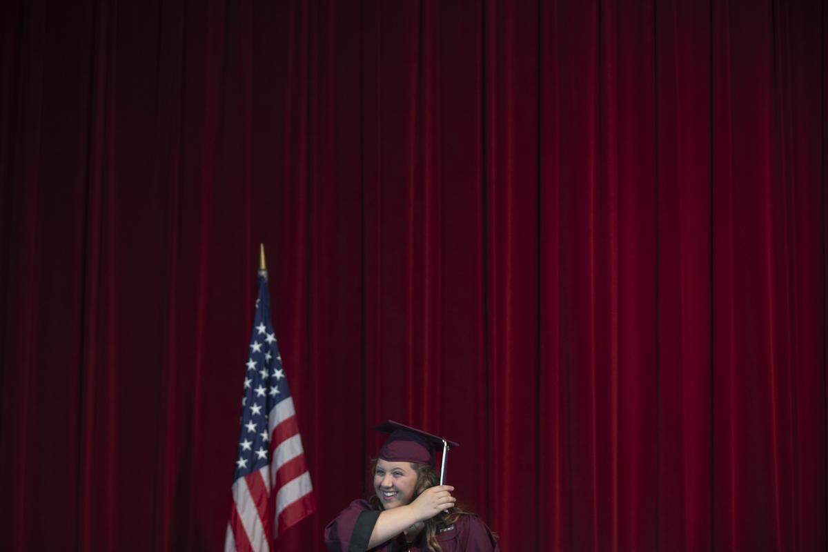 Mara Rogers moves the tassel on her mortarboard during the drive-thru graduation May 20 at Pulaski County High School. Graduates walked across a stage as they were being filmed moving the tassel on their mortarboards.