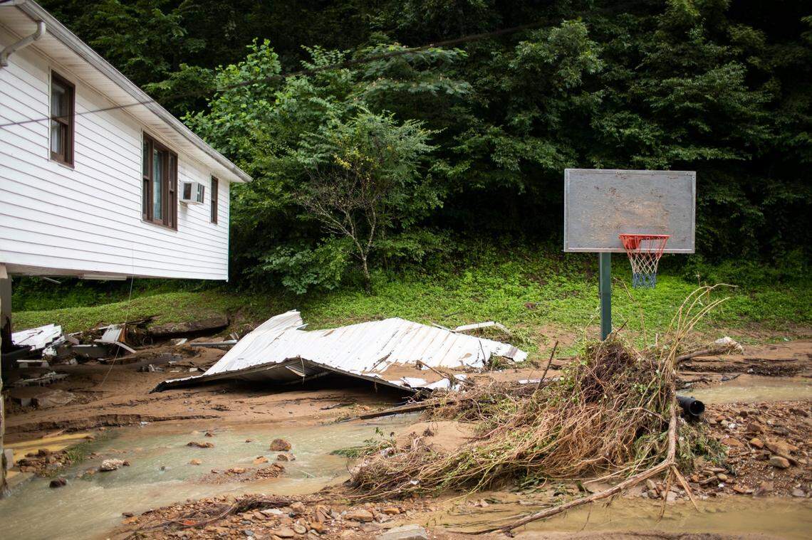 Debris is piled against a basketball goal while an apartment leans after losing its support to flooding that swept through the region in Perry County, Ky., Friday, July 29, 2022.