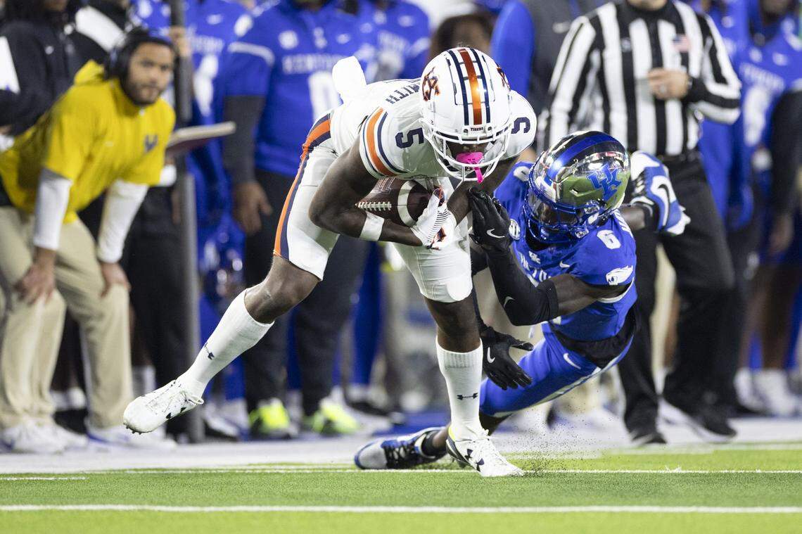 Kentucky defensive back JQ Hardaway, right, attempts to tackle Auburn wide receiver KeAndre Lambert-Smith during Saturday’s game at Kroger Field.