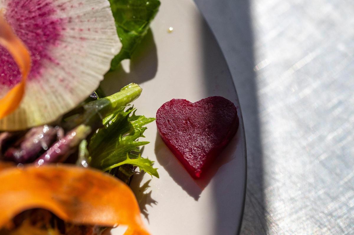 A “heart beet” – a piece of a beet cut in a heart shape — adorns a green salad with honey mustard vinaigrette and goat cheese crouton at the Lemon Tree.