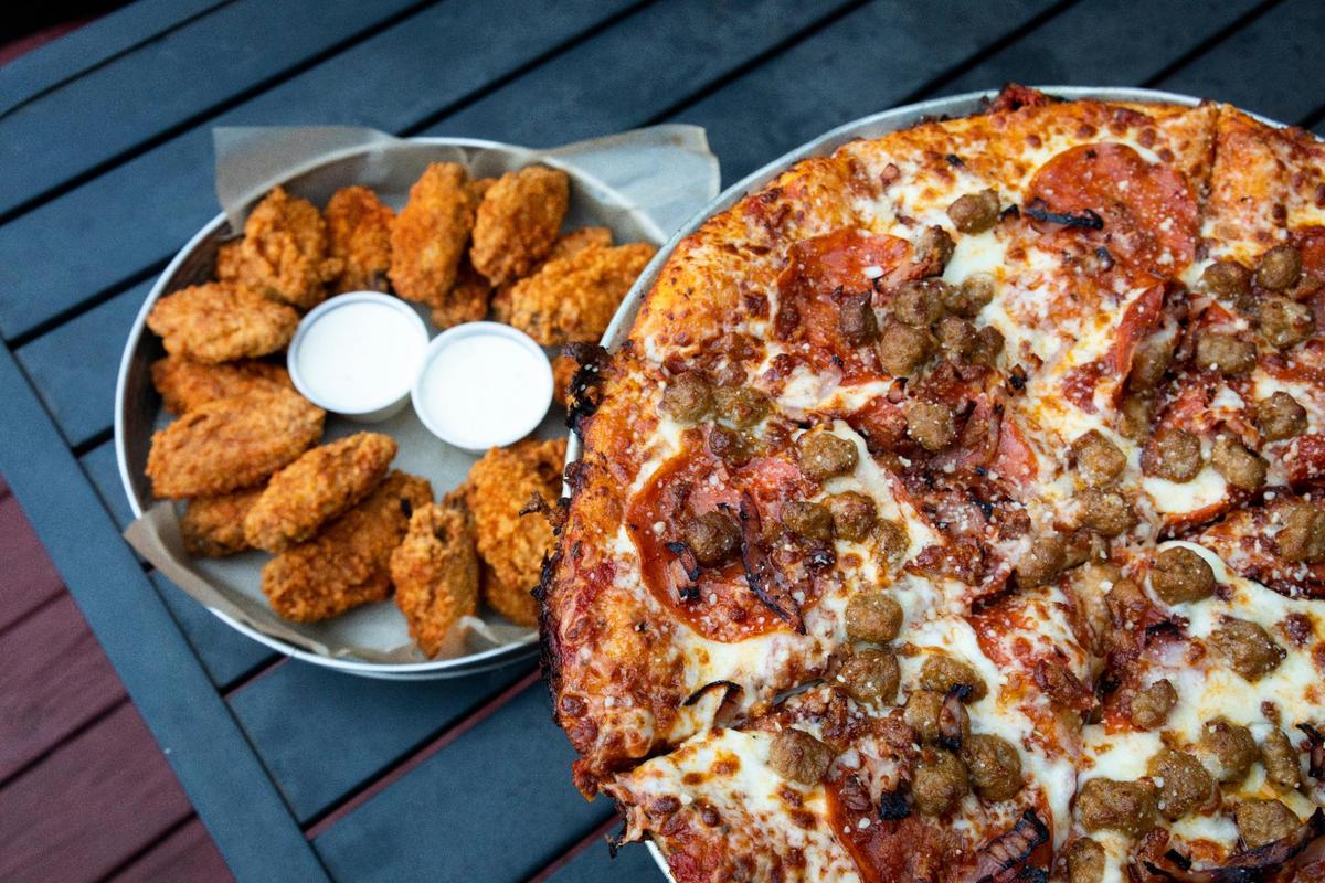 A meat lover’s pizza and Buff Stuff wings from Madison Garden in Richmond. Wings with Buff Stuff seasoning is one the restaurant’s best selling items.