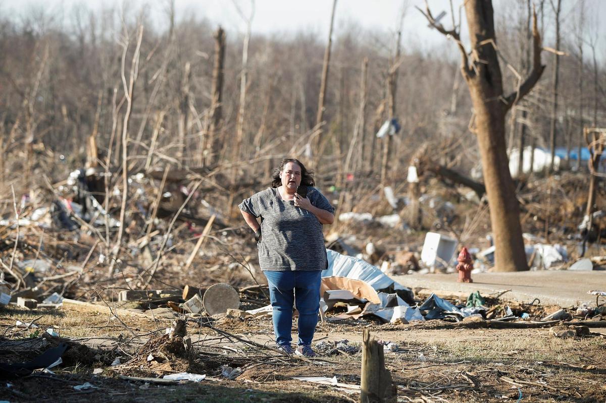 A Bremen, Ky., resident speaks into her phone near the wreckage of her home in Bremen, Tuesday, Dec. 14, 2021.