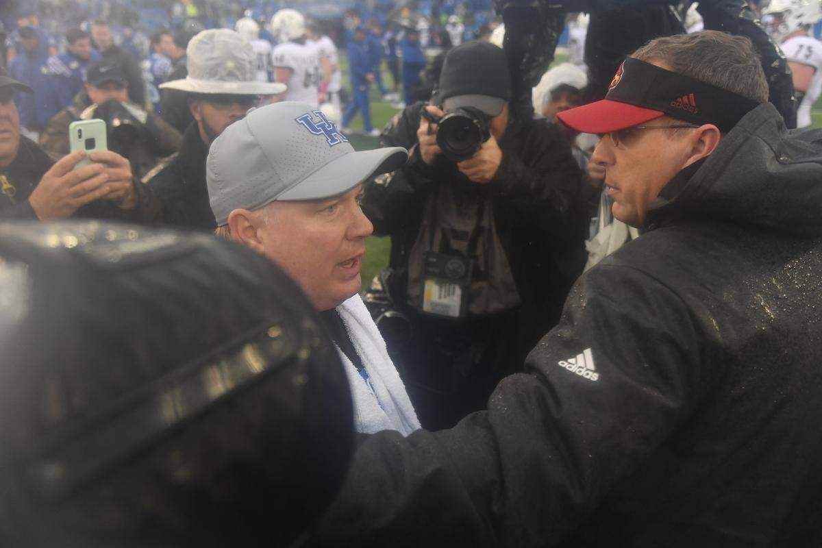 Louisville Coach Scott Satterfield, right, greeted Kentucky Coach Mark Stoops on the playing surface at Kroger Field following the Wildcats’ 45-13 demolition of the Cardinals in 2019.