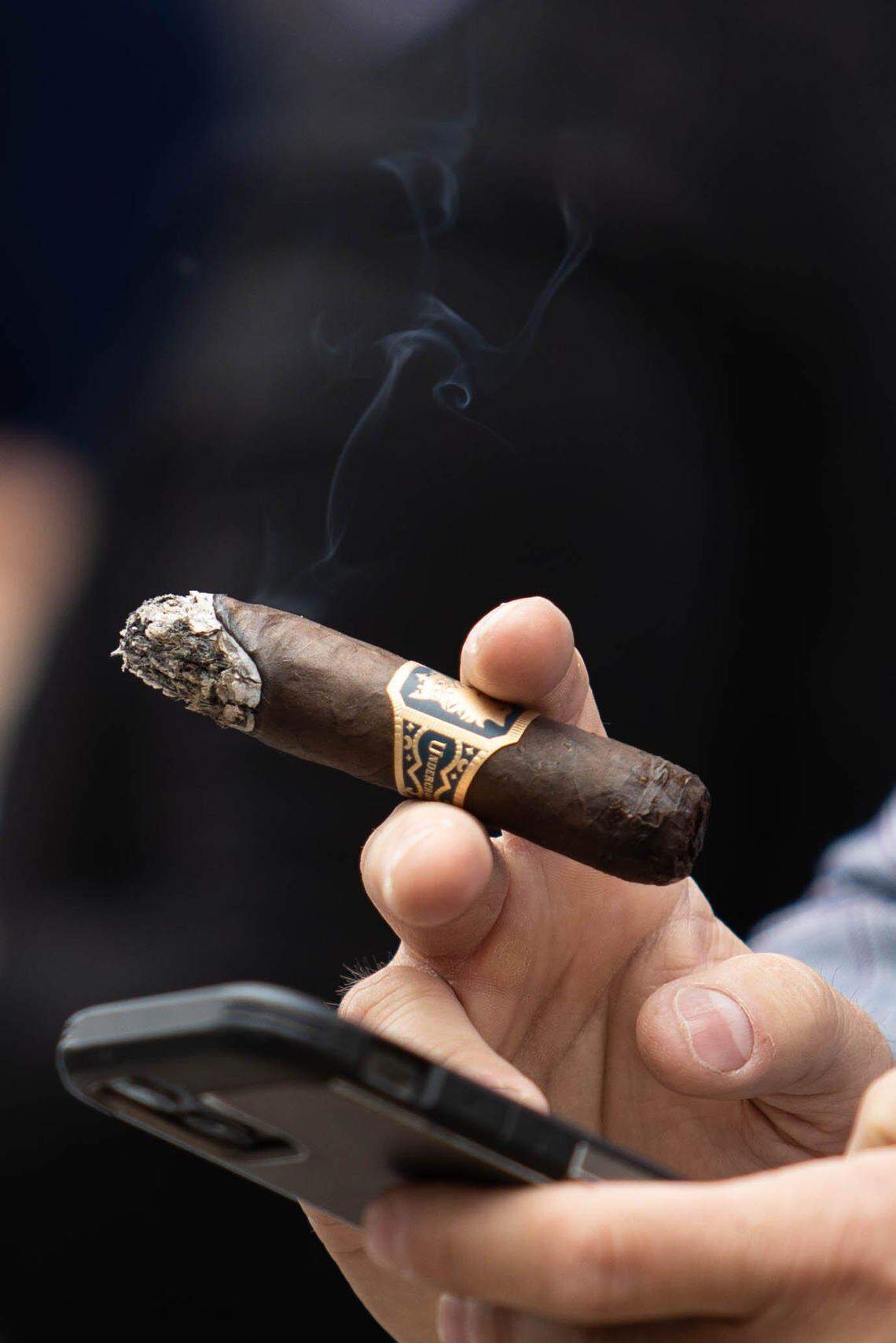 Attendees of the 148th running of the Kentucky Derby smoke their cigars while walking around the Churchill Downs grounds in Louisville, Ky., on Saturday, May 7, 2022. (Grace Ramey/photo@bgdailynews.com)