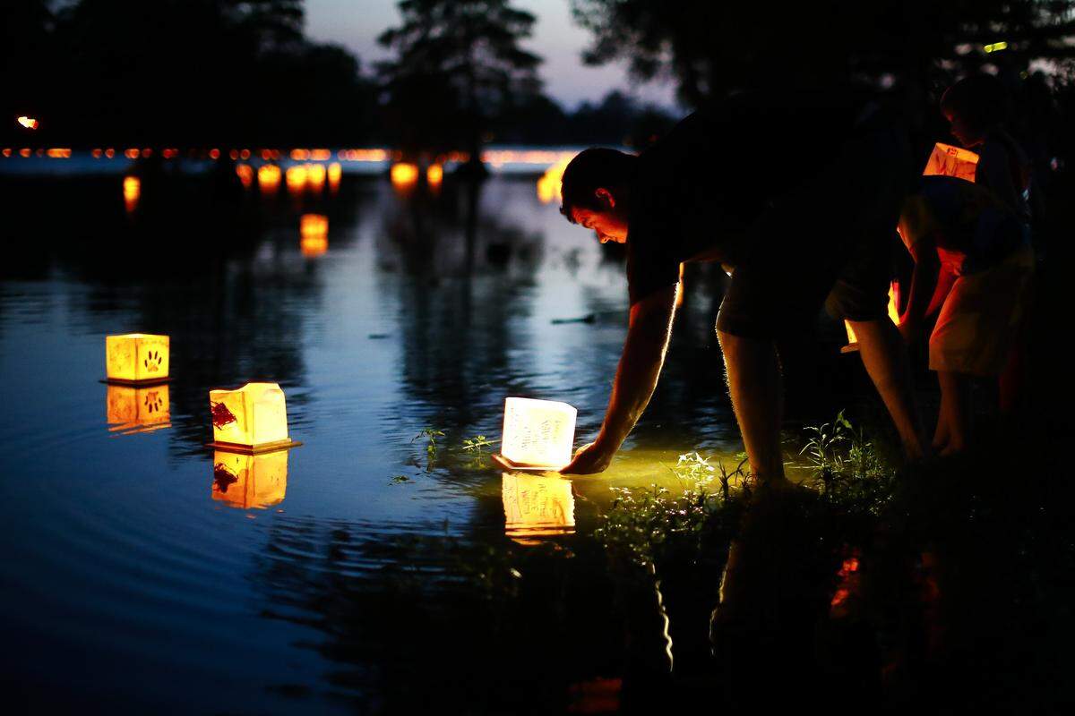 Alex Aube, of Lexington, Ky., launches a water lantern in the lake during the Water Lantern Festival at Jacobson Park in Lexington, Saturday, June 22, 2019. The Water Lantern Festival tours multiple cities throughout the year and donates all proceeds to charity.