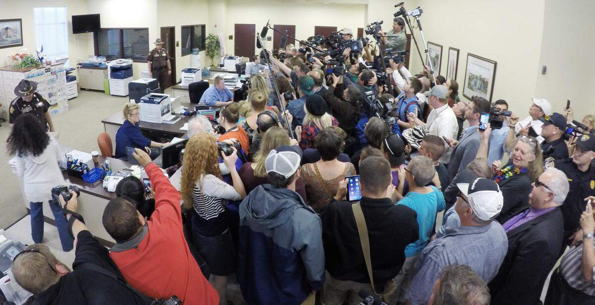 A crowd of media surrounded Carmen Wampler-Collins and Shannon Wampler-Collins as they applied for a marriage license at the Rowan County courthouse in Morehead on Monday. They were the first couple to obtain a license after Clerk Kim Davis returned to work for the first time after spending five days in jail.