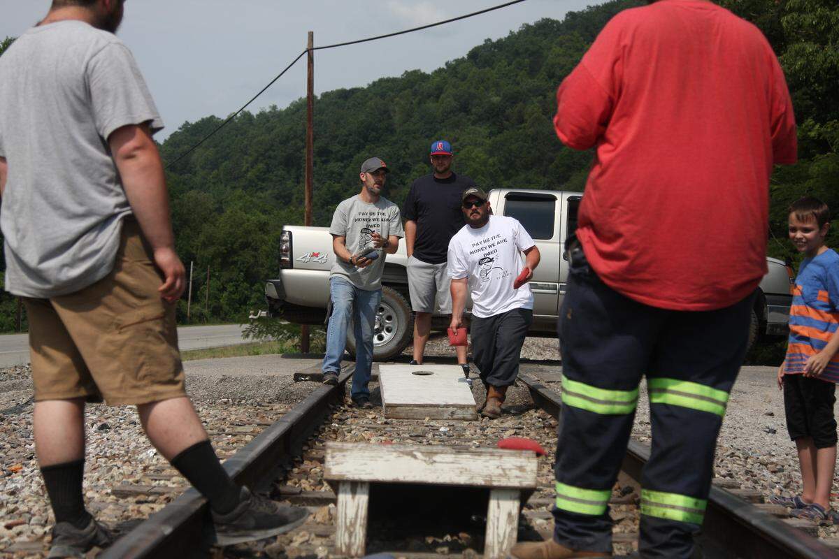 Out-of-work Blackjewel miners play a game of corn hole on the railroad tracks near Cumberland on Tuesday after blocking a train in July.