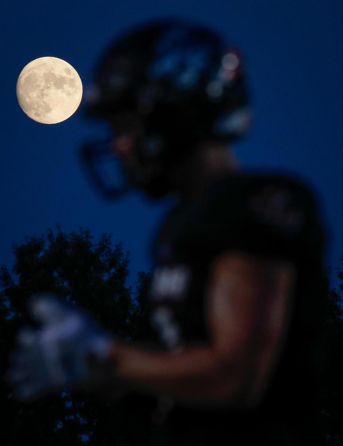 The moon rises over Paul Laurence Dunbar’s JT Seltsam (7) during a game against Breathitt County at Paul Laurence Dunbar High School in Lexington, Ky., Friday, Aug. 20, 2021. Paul Laurence Dunbar beat Breathitt County 69-28.