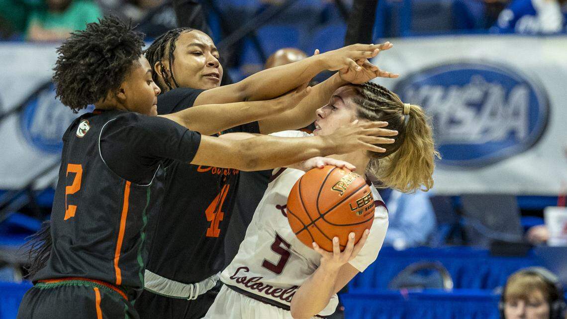 Henderson County’s Adalyn Gish (5) is trapped by Frederick Douglass’ Adrianna Brown (2), left, and Tamia Waide (4) during their first-round game of the 2026 Clark’s Pump-N-Shop Girls’ Basketball Sweet 16 on Wednesday at Rupp Arena .