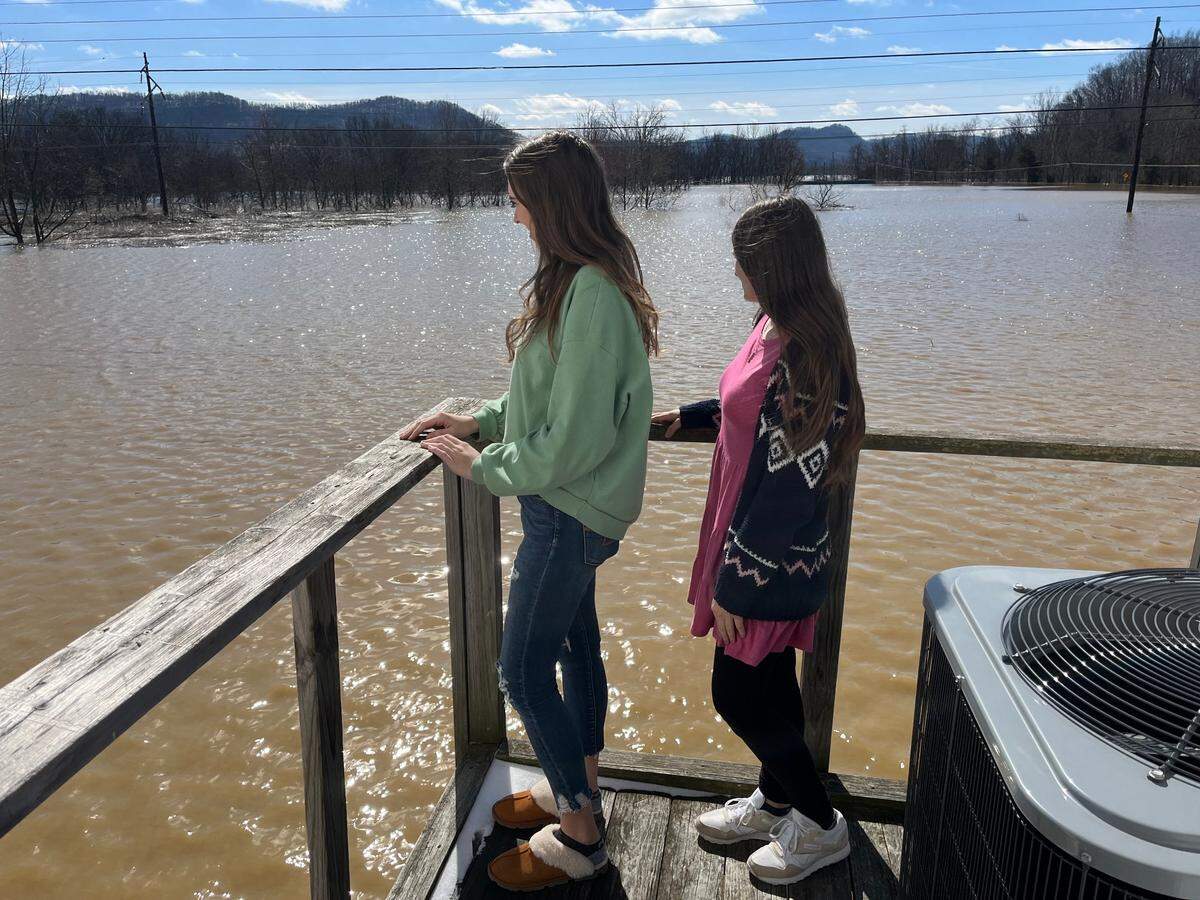 Chynna Hardy, co-owner of Chynna’s Small Town Shop, surveys the floodwaters behind her shop with her niece, AnClair Hardy