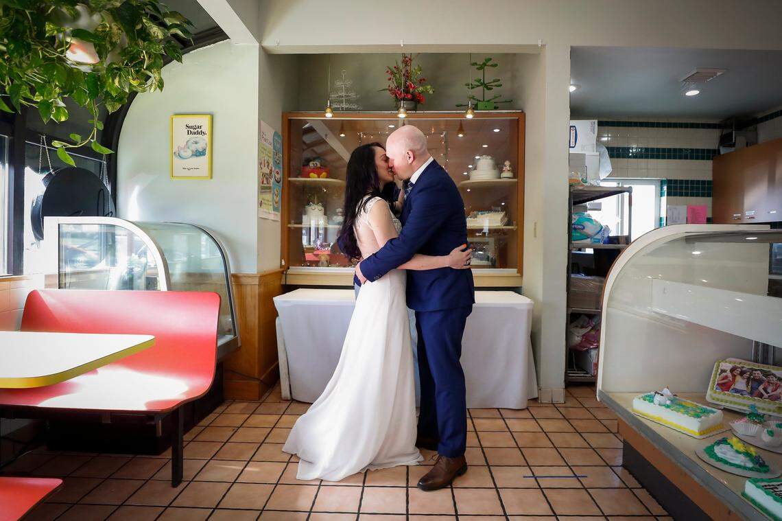 Heather Sutton and Brandon Puckett, both of Lexington, Ky., kiss during their wedding ceremony at Donut Days Bakery in Lexington, Ky., Friday, March 19, 2021. Puckett, who is a police officer, and Sutton, an EMT, met on the social media app TikTok. A forecast of bad weather gave Sutton the idea to hold the ceremony at Donut Days. “How would it be if maybe we could could get married in the doughnut shop, because you know police officers they love the doughnuts. So I thought that was a good way to lure him here, was a whole shop full of doughnuts,” Sutton joked.