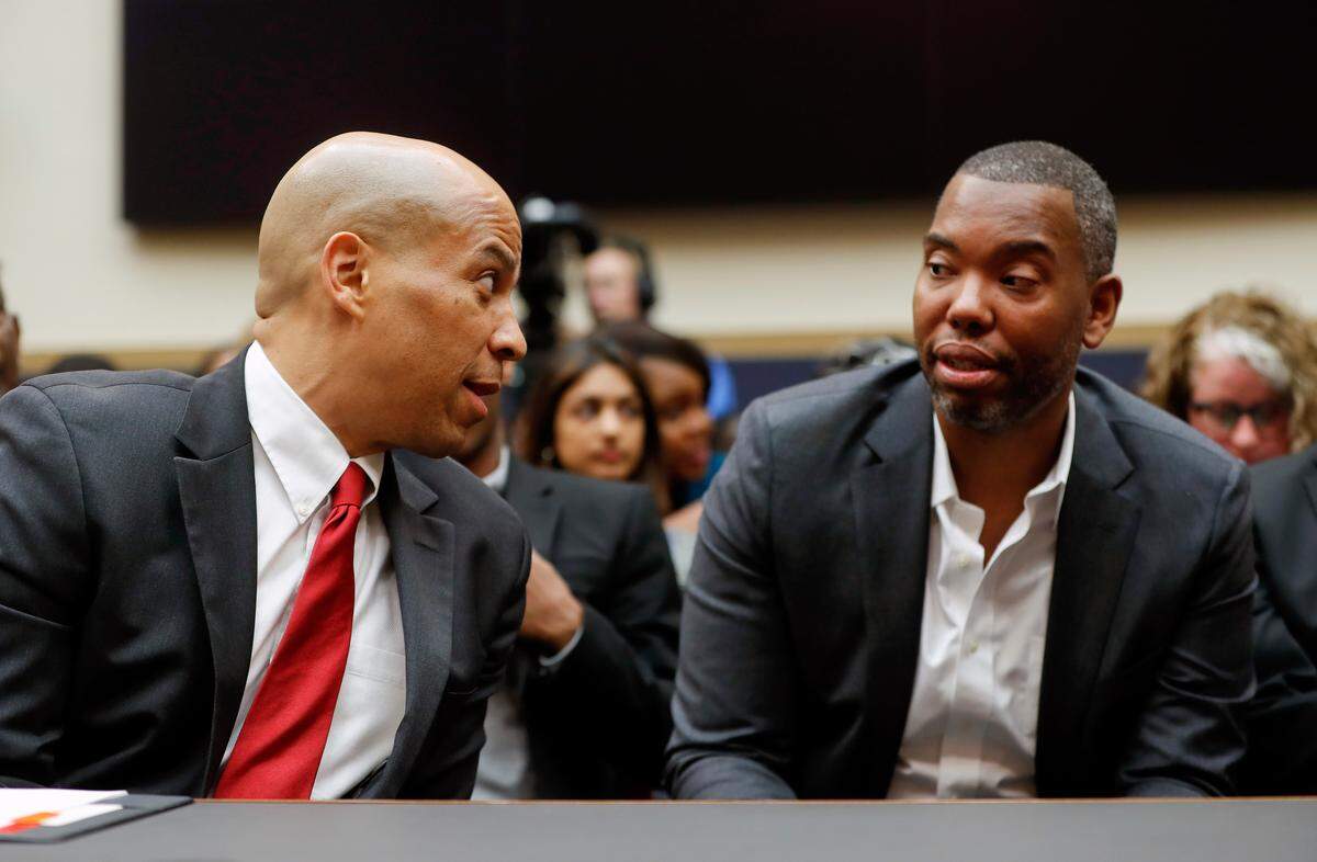 Democratic Presidential candidate Sen. Cory Booker, D-N.J., left, talks with author Ta-Nehisi Coates, right, as he waits to testify about reparation for the descendants of slaves during a hearing before the House Judiciary Subcommittee on the Constitution, Civil Rights and Civil Liberties, at the Capitol in Washington, Wednesday, June 19, 2019. (AP Photo/Pablo Martinez Monsivais)