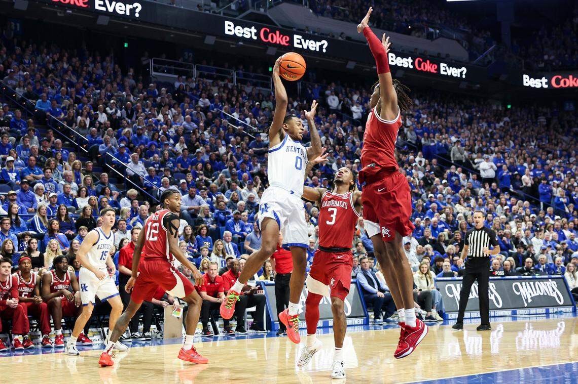 Kentucky guard Rob Dillingham (0) passes the ball around the Arkansas defense during Saturday’s game at Rupp Arena.