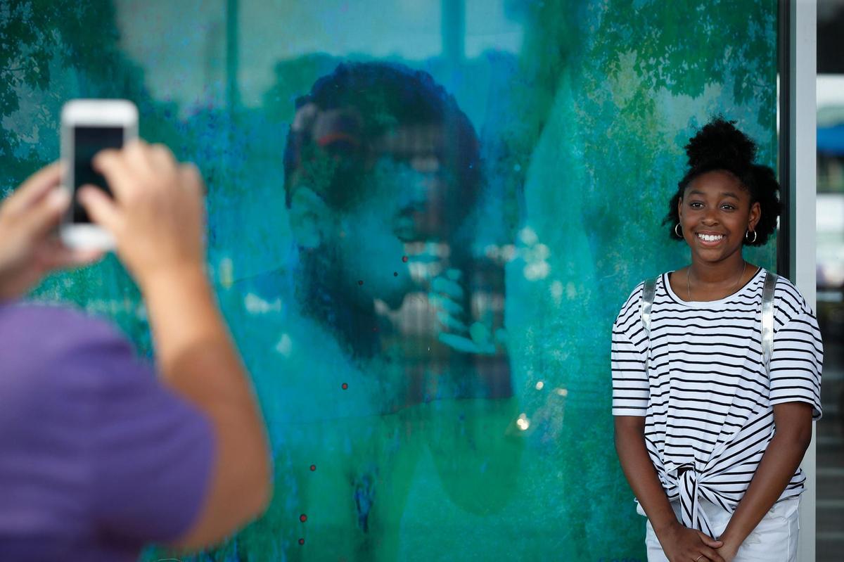 Zaria Barber, 11, of Lexington, has her picture taken with one of the panels in the “I Was Here” project at Lexington Legends Ballpark,June 26, 2021. The new piece of the art project will soon have a musical augmented reality to help tell the stories.
