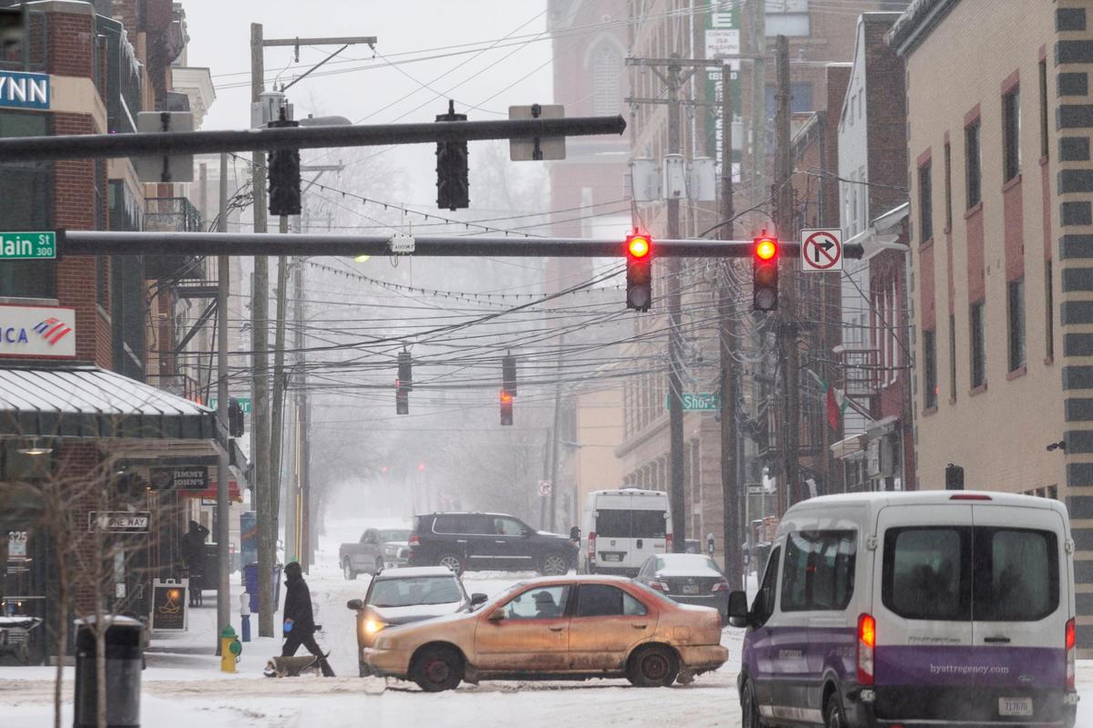 Pedestrians walk through the snow and ice covered streets and sidewalks in Lexington, Ky., Monday, February 15, 2020. Lexington is currently under a ice storm warning according to the National Weather Service. Chances of snow and ice are expected through the majority of the week.