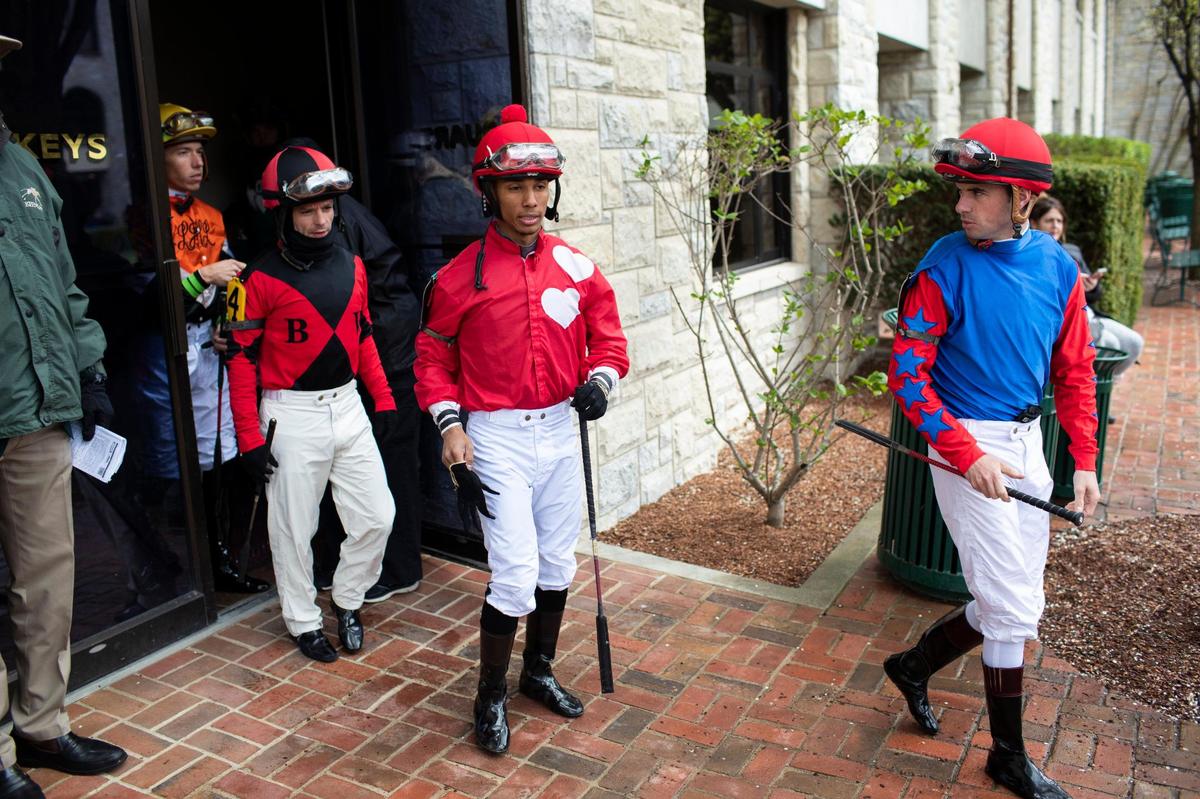 The jockeys leave their quarters before one of Friday’s 10 opening-day races.