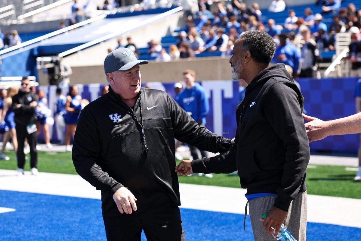 Kentucky football head coach Mark Stoops greets women’s basketball head coach Kenny Brooks during the Blue-White Game at Kroger Field on April 13.