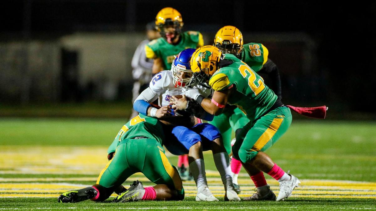 Madison Central’s Brady Hensley (42) is tackled by Bryan Station’s Dahvon Frazier (34), left, and Bryan Station’s Nikalos Dixon (23) during a high school football game between Bryan Station and Madison Central at Bryan Station High School in Lexington, Ky., Friday, Oct. 21, 2022.