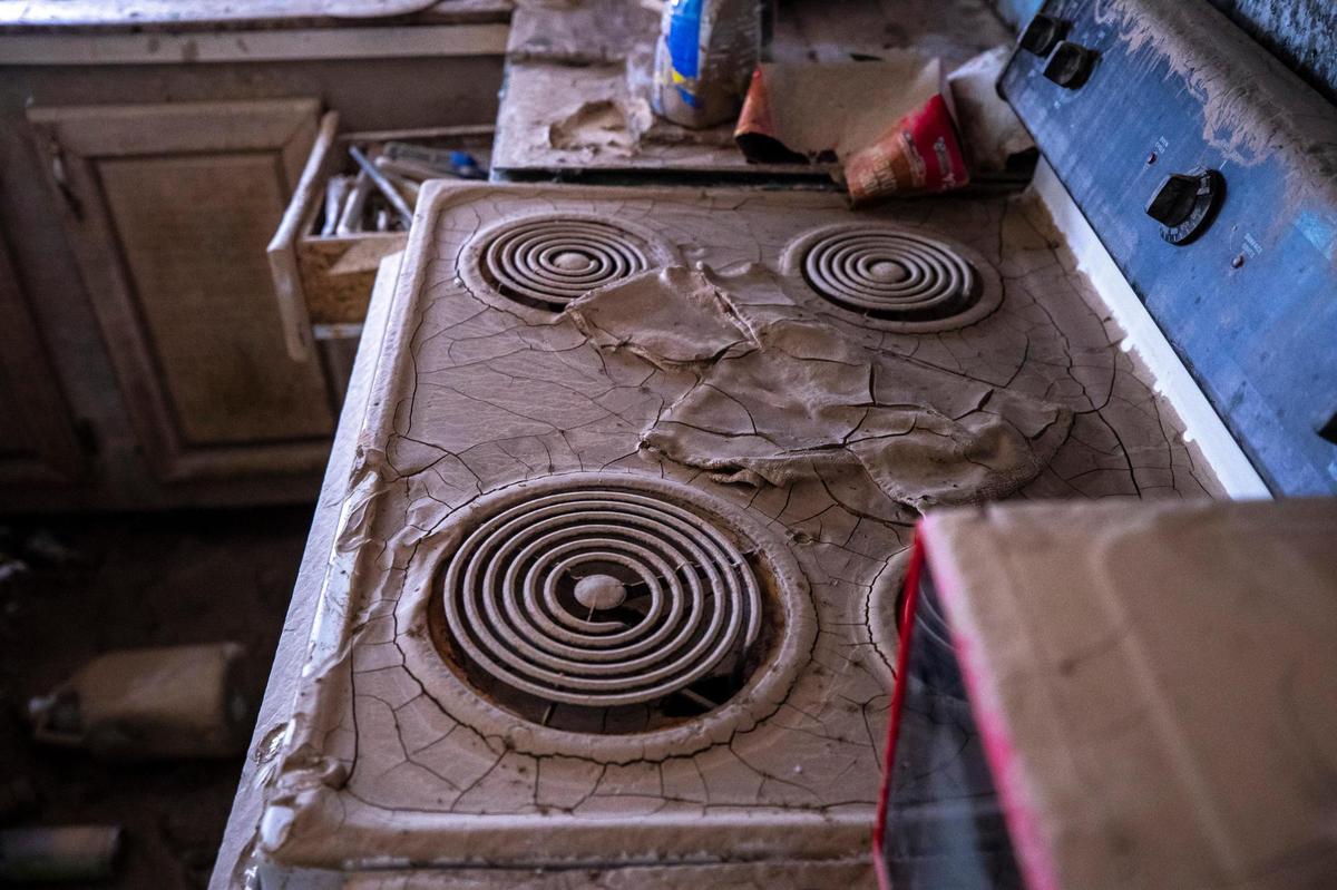 Dried mud cakes the stovetop at Wiley Messer’s home in Perry County, Ky., on Tuesday, Aug. 23, 2022. The home was severely damaged by flood waters last month.
