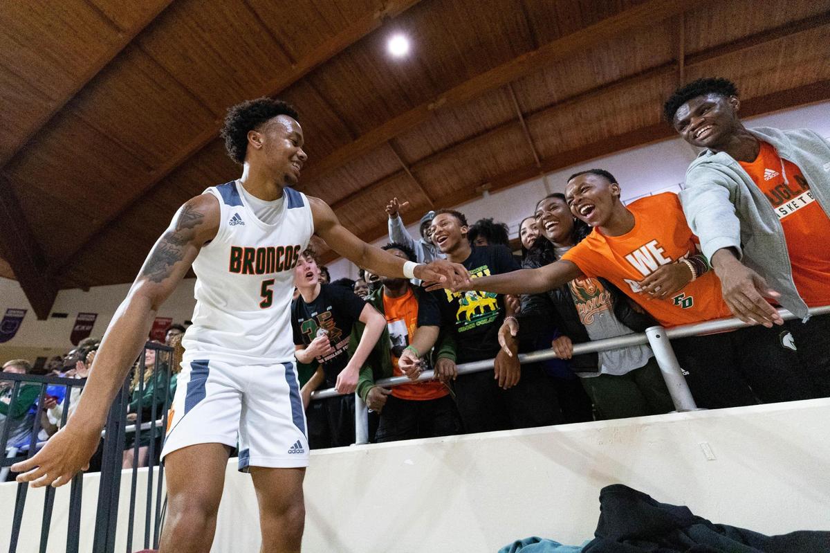 Frederick Douglass guard Tylon Webb celebrates with the student section after the Broncos defeated Madison Southern in the 11th Region semifinals Friday.