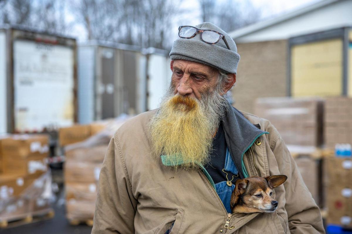 Henry Tolson, with his dog, Wiener, volunteer at the Hazel Green Food Project on a distribution day in Hazel Green, Ky., on Friday, Nov. 22, 2024.