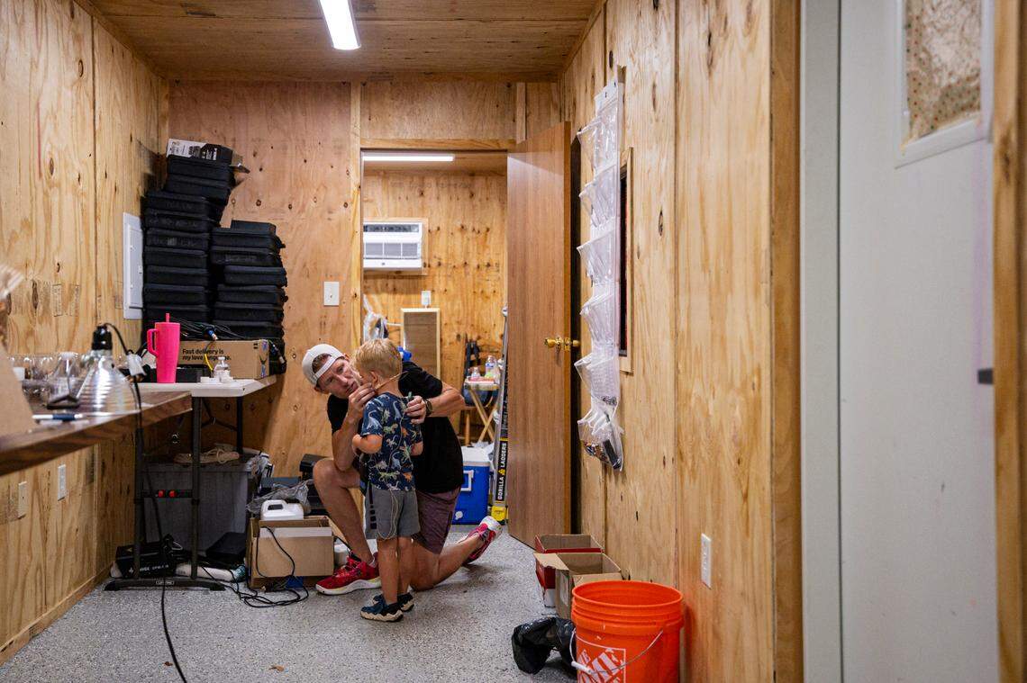 Ian Scott fastens a microphone to, his son, Owen’s head during a showing of Romeo and Juliet on Friday, July 18, 2025, at Woodland Park in Lexington, Ky.