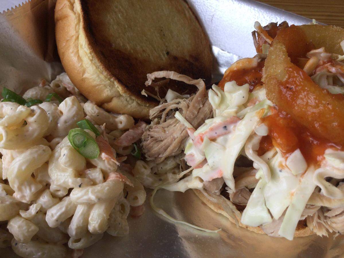 Big Kahuna’s Kalua Pork Sandwich is slow-roasted marinated pork, Hawaiian BBQ sauce, with an onion ring and slaw, on a toasted bun.