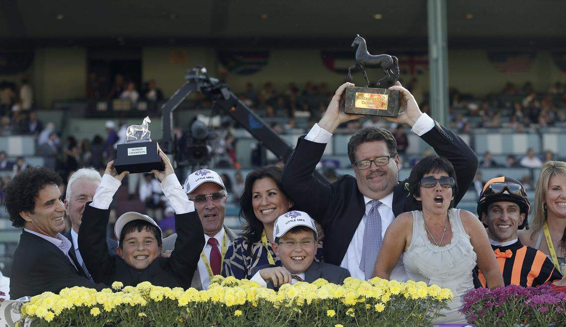 Carlo Vaccarezza, fourth from left wearing sunglasses and a hat, celebrates in the winner’s circle after Little Mike won the 2012 Breeders’ Cup Turf horse race at Santa Anita Park in Arcadia, Calif.