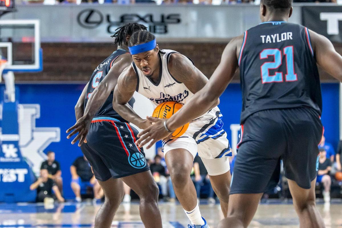 La Familia’s Archie Goodwin (10) tries to drive past Eberlein Drive’s Anthony Clemmons (5) and Terry Taylor (21) during the Lexington Regional championship game of The Basketball Tournament on Tuesday at Memorial Coliseum.