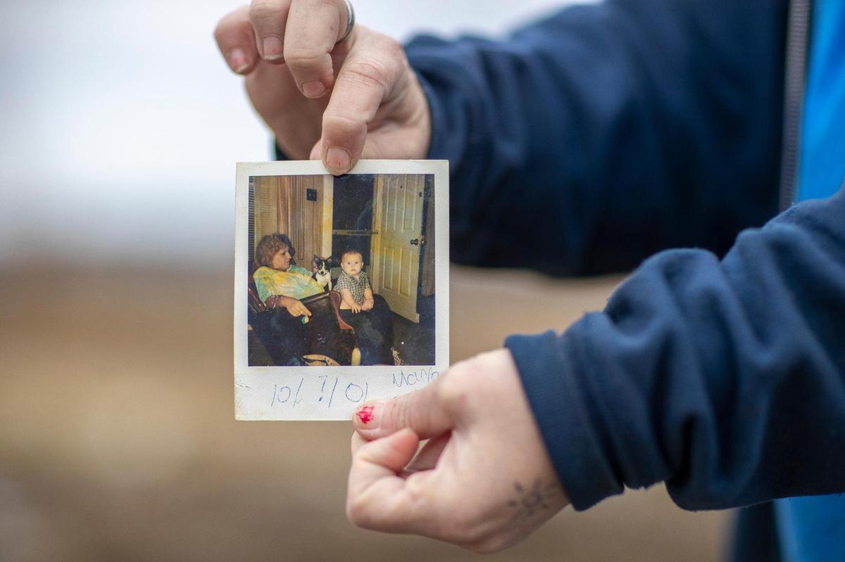 Toskia Adamson holds a photograph of her mom, Geneva Adamson, and her son, Skyler Lohse, that was lost when a tornado destroyed her mother’s home in Dawson Springs, Ky., on Dec. 10, 2021, during the historic quad-state tornadoes that scoured a path of destruction nearly 200 miles. Adamson was able to recover some photos that had been blown across state lines through a Facebook group dedicated to helping reunite tornado victims with lost items.