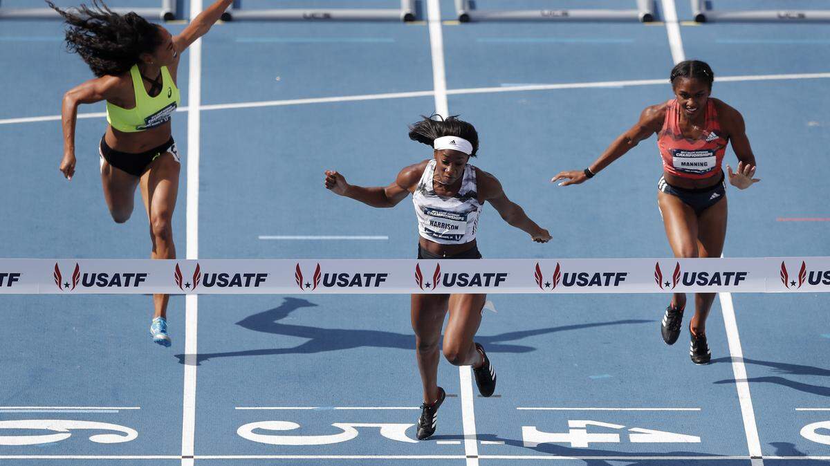Former Kentucky track athlete and world record holder Keni Harrison, center, crossed the finish line ahead of Queen Harrison, left, and Christina Manning, right, while winning the women's 100-meter hurdles final at the U.S. Championships Saturday, June 23, 2018, in Des Moines, Iowa.