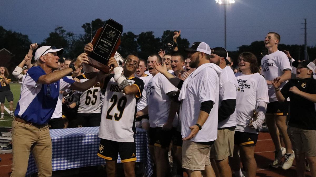 Woodford County’s Jeremiah Dale (29) of holds the Commonwealth Lacrosse League boys state title on his team’s behalf following its victory against Henry Clay at Transylvania University’s Pat Deacon Stadium on Saturday.