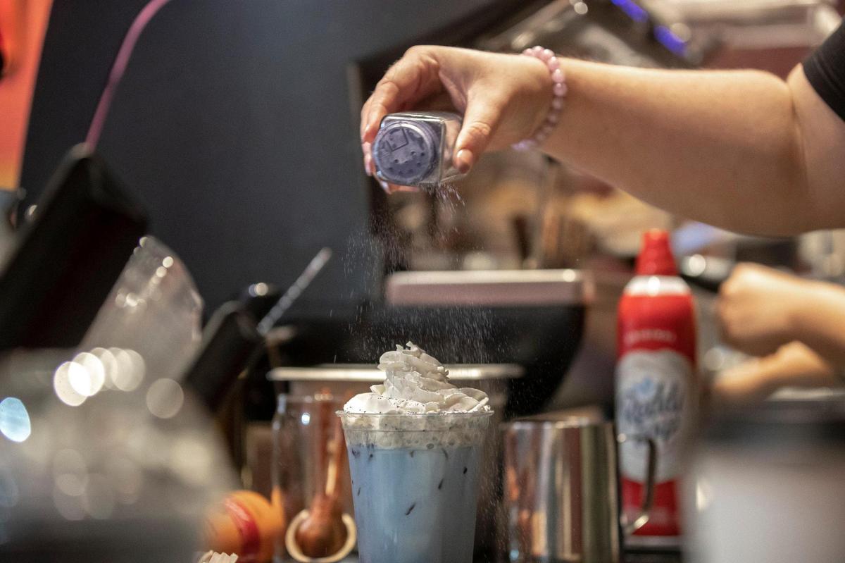 Audra Jones, a manager at The Creatures’ Cauldron Cafe, makes a drink called the Wolfsbane Potion at the cafe on Thursday, Sept. 22, 2022.