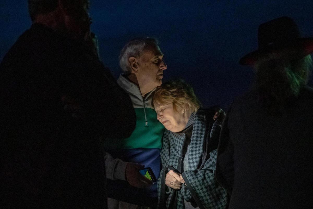 Terry and Ruth Ann Harrell embrace following a Christmas Eve service with members of Mayfield First Presbyterian Church and Mayfield First Christian Church in an empty lot between their destroyed church buildings.