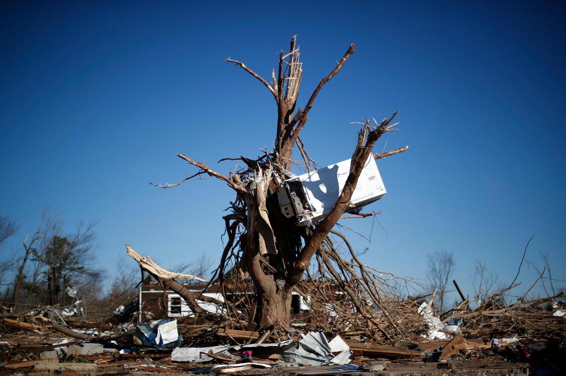A refrigerator sits suspended in a tree along East Hall Street in Dawson Springs, Ky., Monday, Dec. 13, 2021.