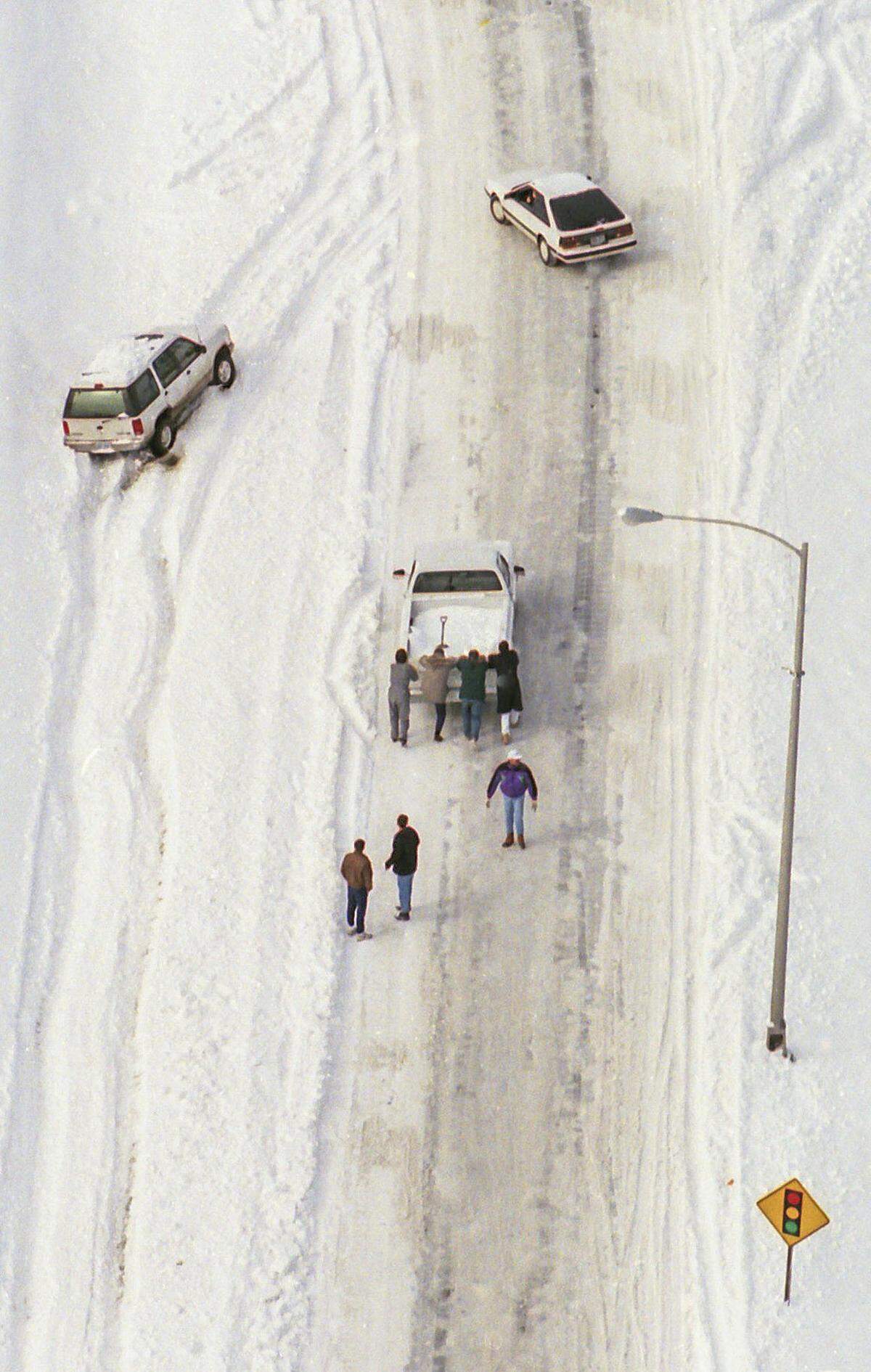 Fellow motorists helped a pickup get up the ramp of New Circle Road to Nicholasville Road January 19, 1994, two days after a winter storm dumped 10 inches of snow on Lexington. Photo by Ron Garrison | Staff