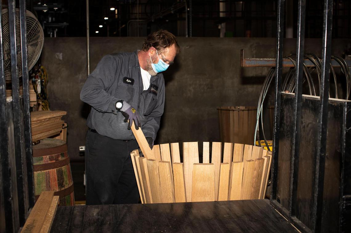 Workers at Cumberland Cooperage in Laurel County use dried staves made from white oak logs to make 53-gallon barrels used in aging bourbon in this Dec. 13, 2021 photo.