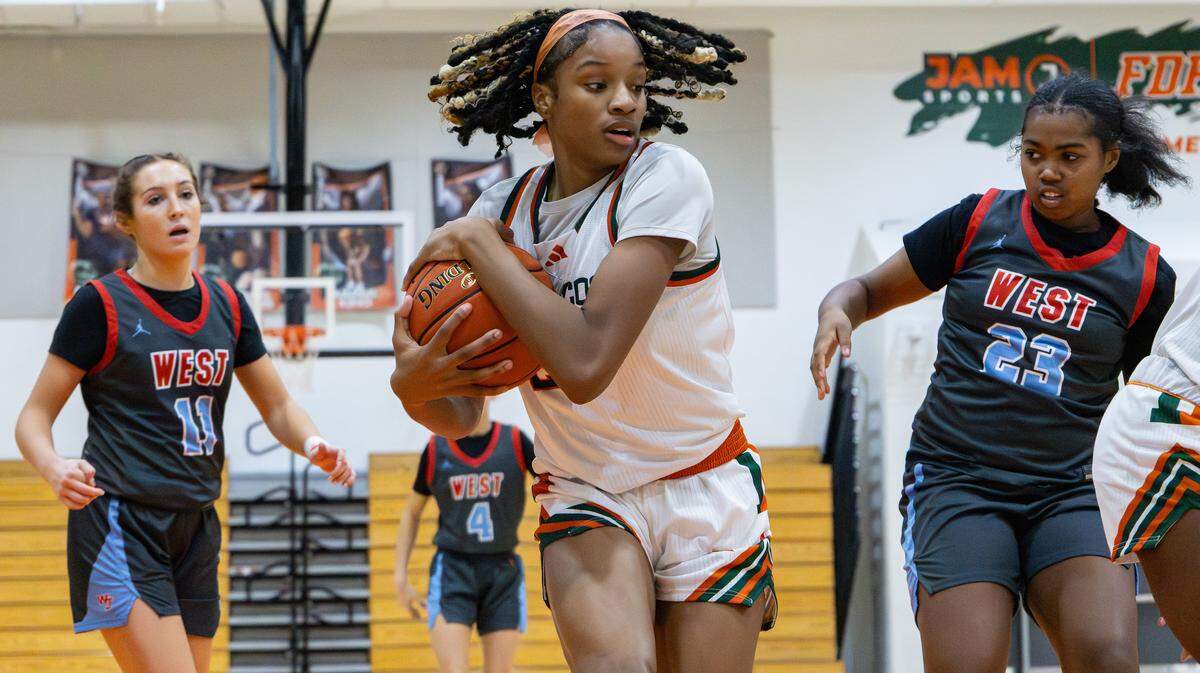 Douglass's Jaelee Knowles (#23) safeguards the ball after a rebound from Jessamine's Zaria White (#23) and Katie Mastin (#11) during the West Jessamine vs Frederick Douglass girls basketball game on Jan. 14, 2026, in Lexington, Ky.