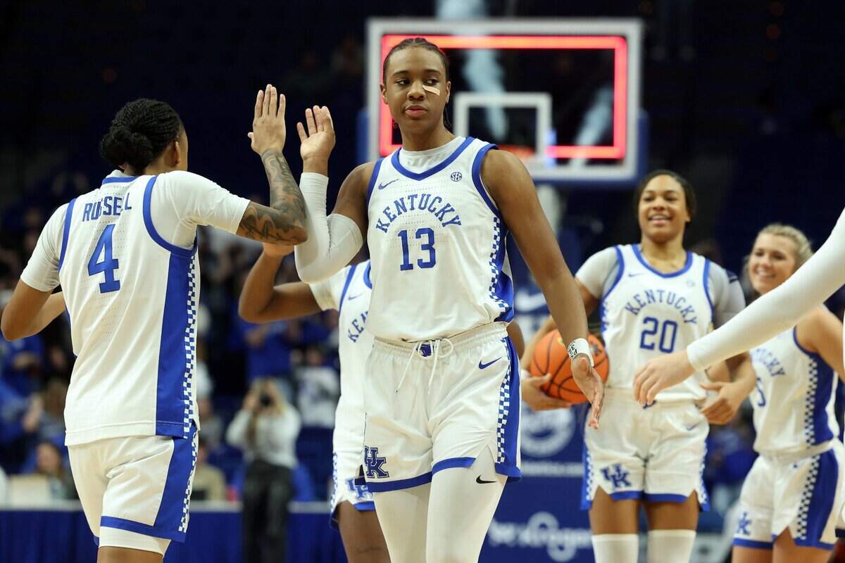 Kentucky players, including Eniya Russell (4) and Ajae Petty (13) celebrate after Sunday’s win against Florida at Rupp Arena.