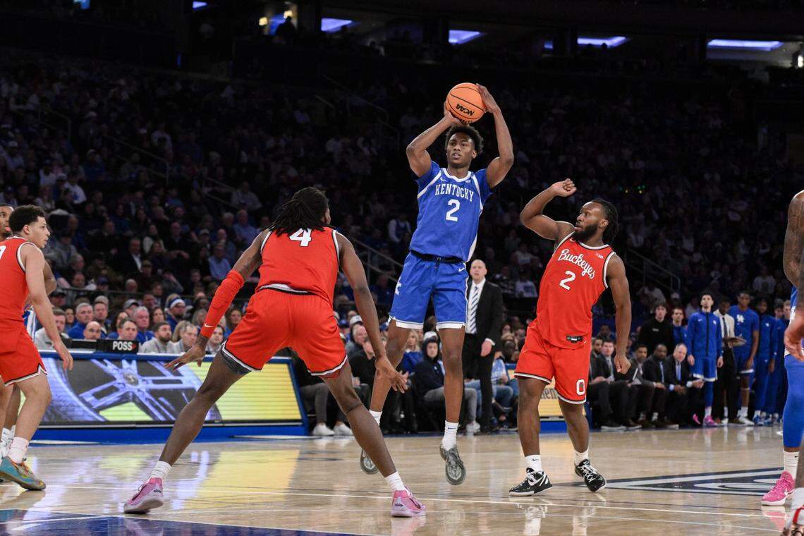 Dec 21, 2024; New York, New York, USA; Kentucky Wildcats guard Jaxson Robinson (2) shoots the ball while being defended by Ohio State Buckeyes forward Aaron Bradshaw (4) and Ohio State Buckeyes guard Bruce Thornton (2) during the first half at Madison Square Garden. Mandatory Credit: John Jones-Imagn Images