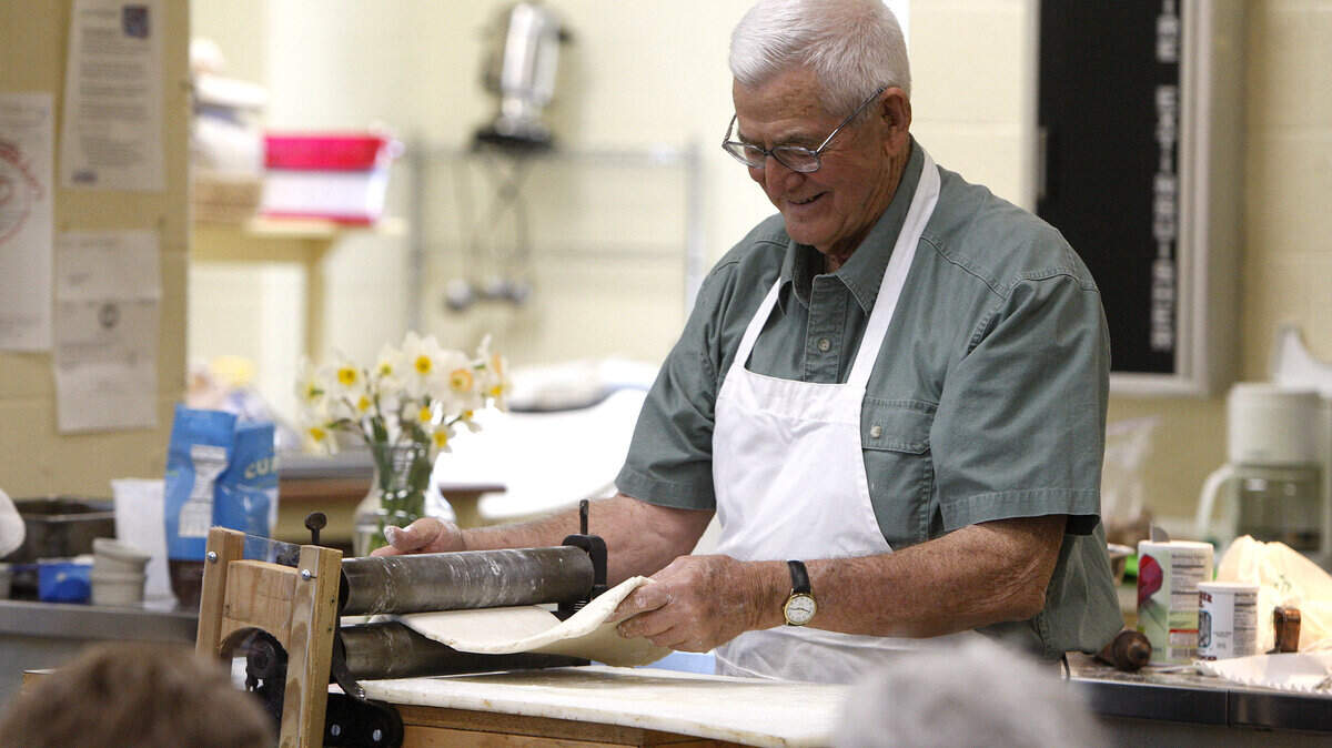 Master beaten biscuit maker Charles Logan fed his dough through a motorized biscuit brake.
