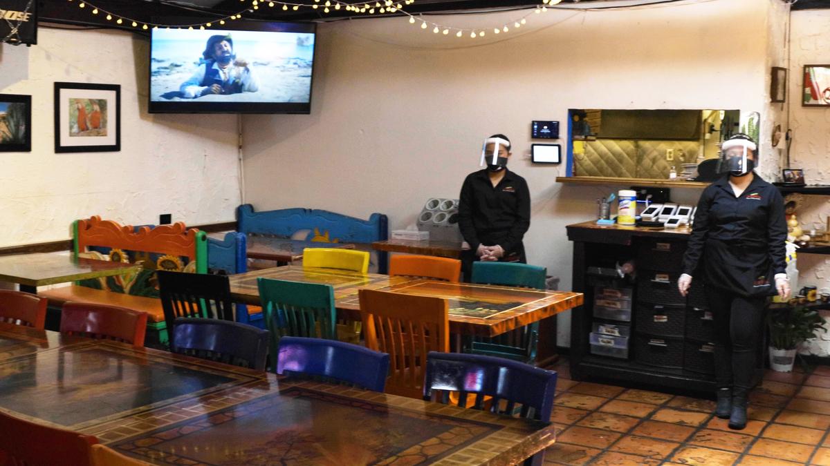 Employees of Papi’s restaurant on Euclid Avenue wore facial masks and covers Friday while serving dining room guests and handling food.